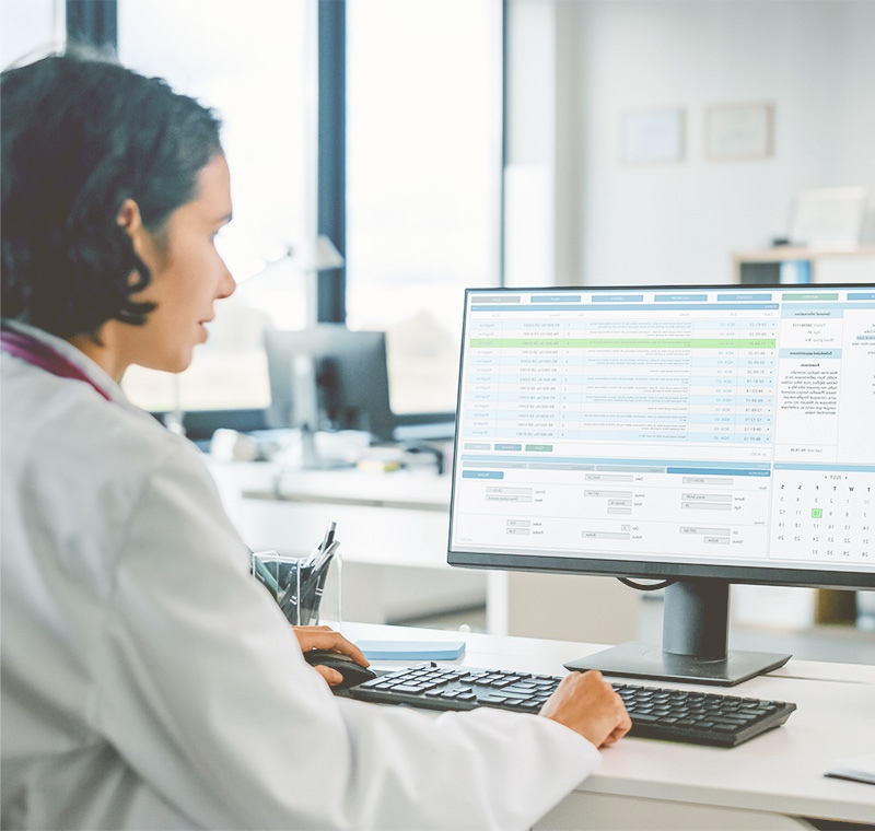 A clinical medical specialist prepares medical instruments on a tray in a bright exam room, ensuring readiness for a patient procedure.