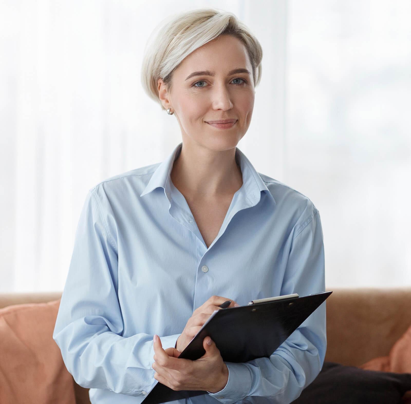 A mental health specialist talks with a young adult in a comfortable office, offering empathy and support while discussing mental health and coping strategies.