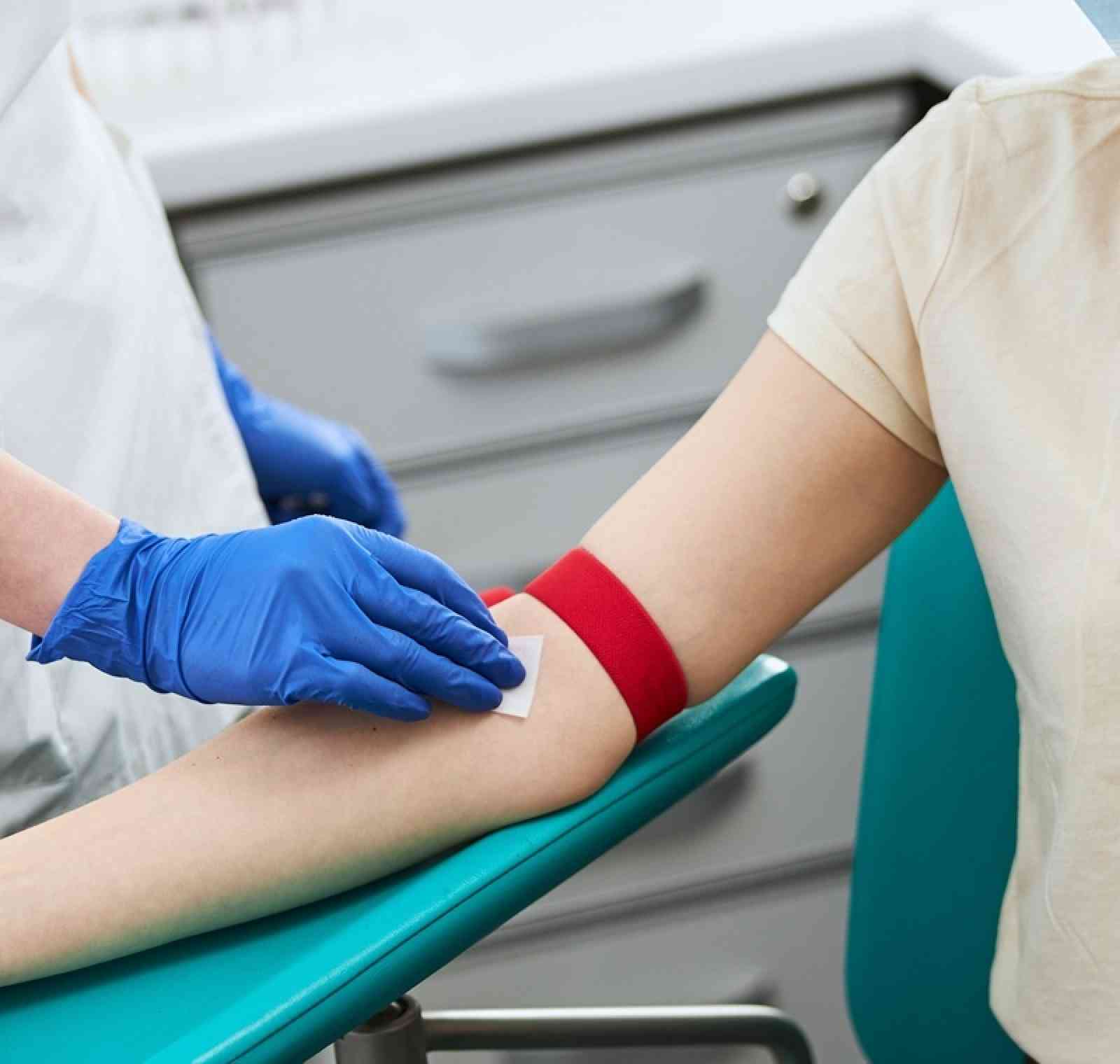 A phlebotomist preparing to draw blood from a patient